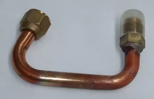 Kupfernes Absaugrohr mit zwei Verbindungsstellen, einer aus Messing, zur Verwendung in Daikin-Systemen. Das Rohr hat eine S-förmige Biegung und eine transparente Abdeckung.